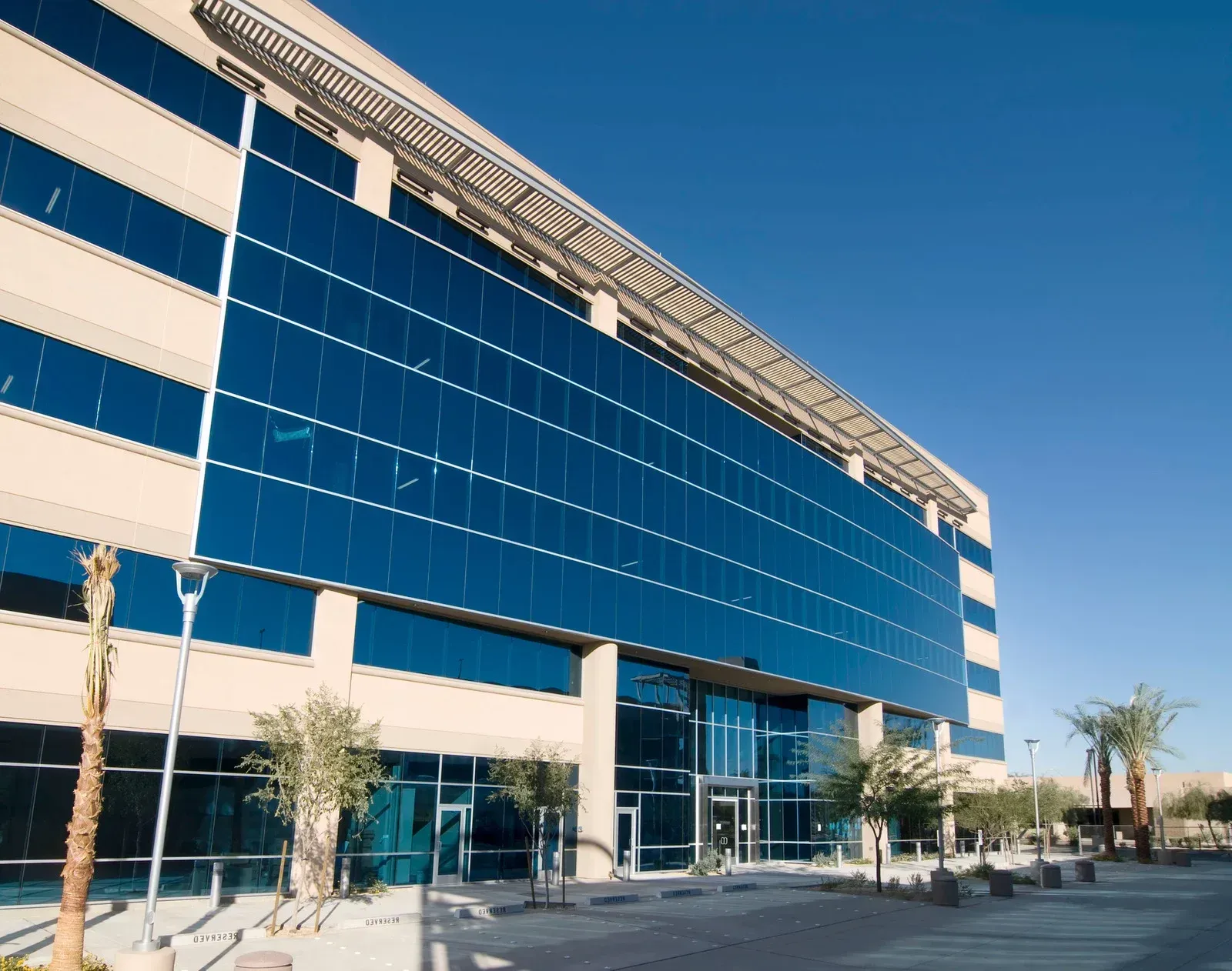 A large building with a lot of windows and palm trees in front of it