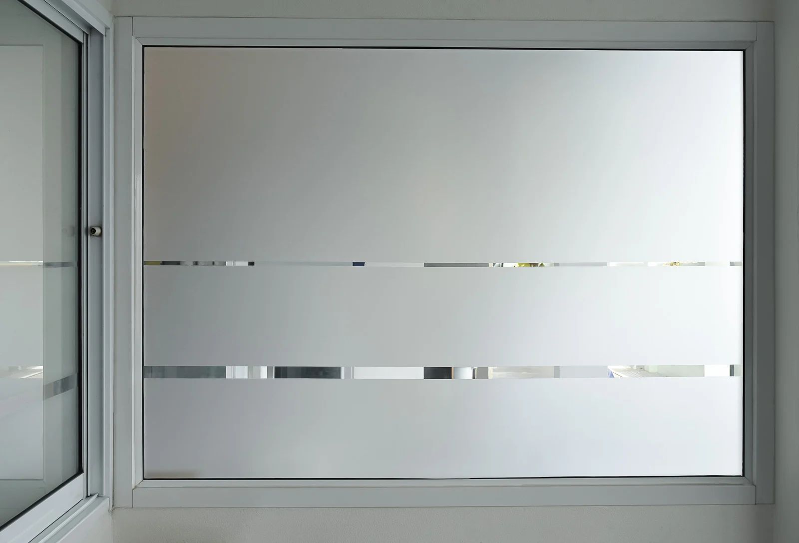 Frosted glass window with two horizontal transparent stripes in a gray frame