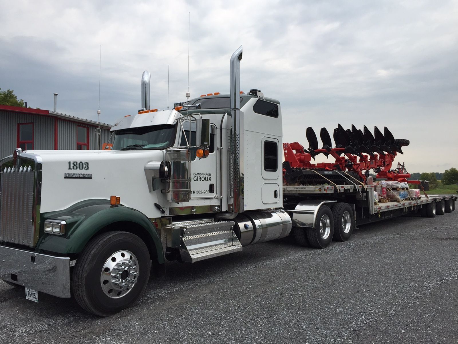 Un gros semi-remorque est garé sur un terrain en gravier.