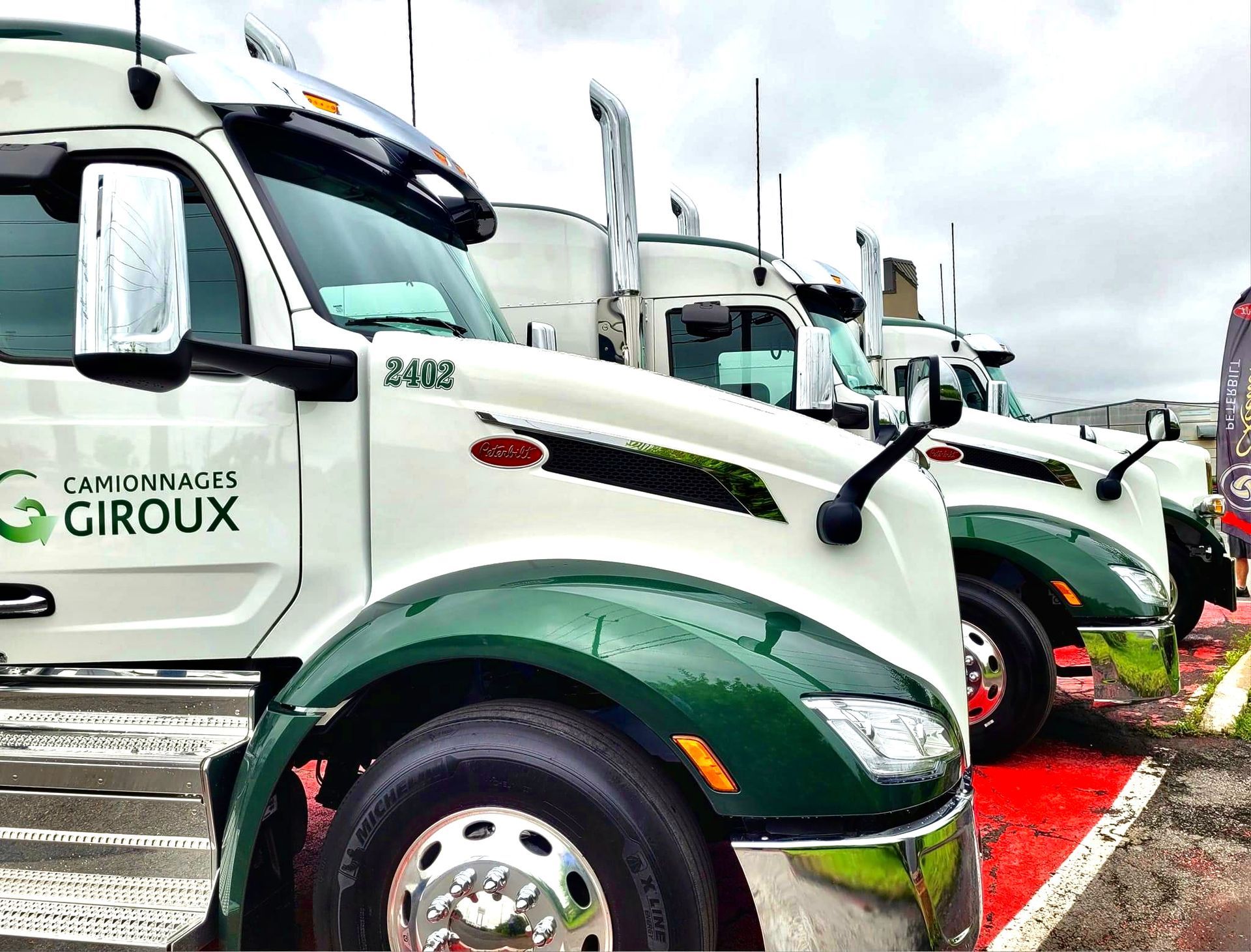 Une rangée de semi-remorques est garée sur un parking.
