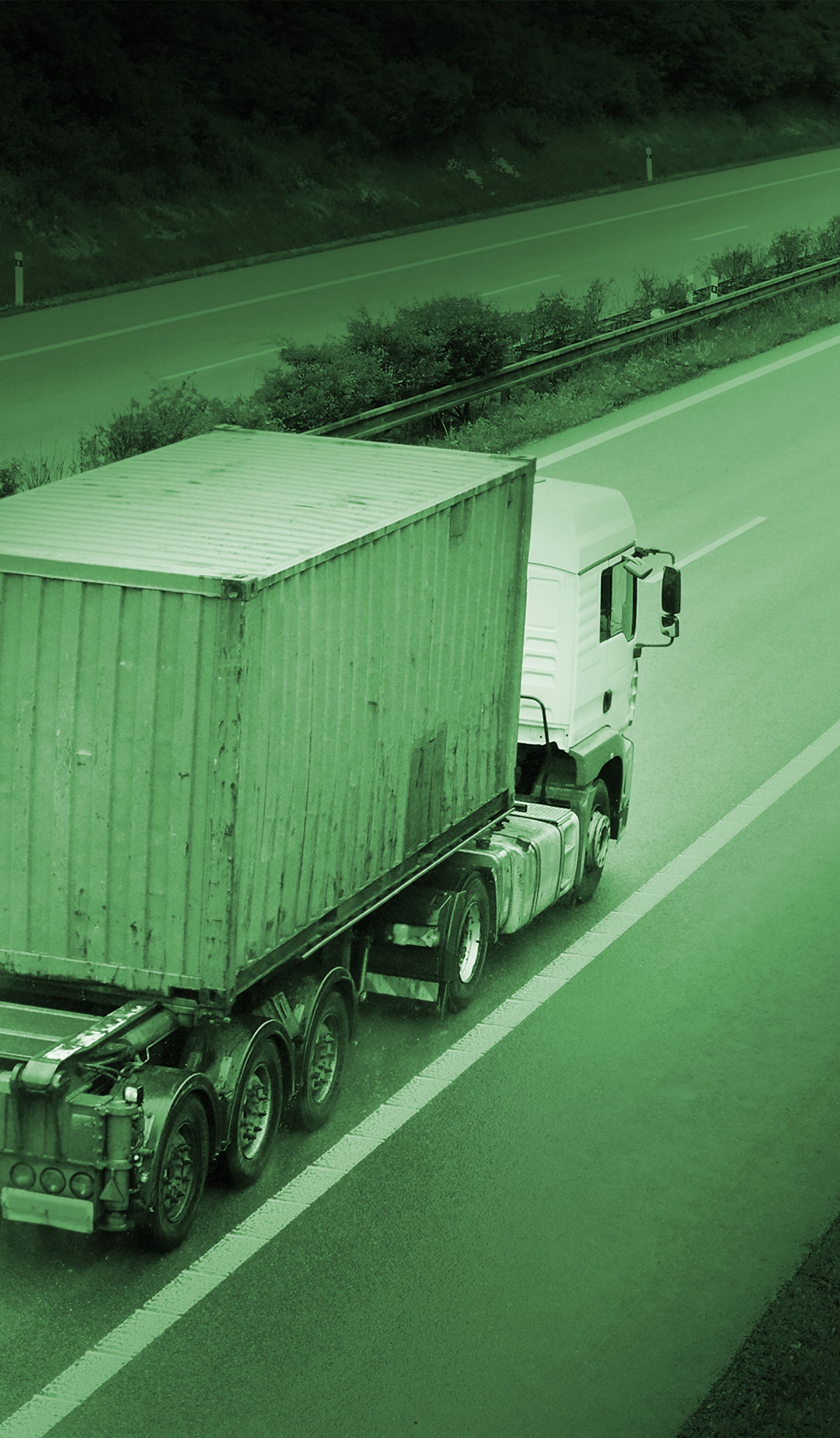 Un semi-camion vert roule sur une autoroute.