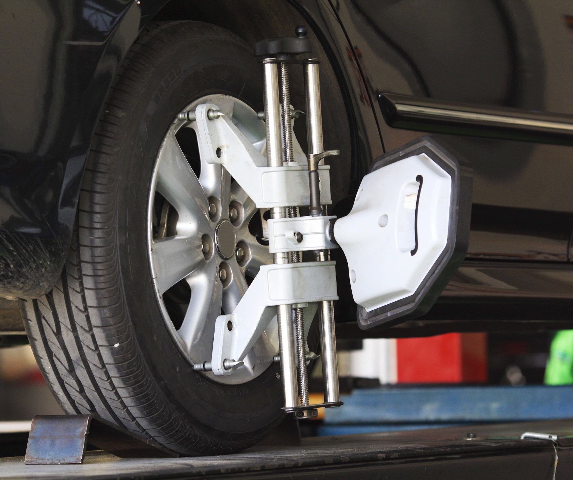 Car tire with wheel alignment equipment attached.