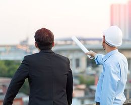 construction worker explaining plans to businessman