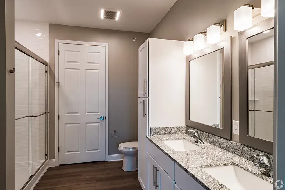 A bathroom with two sinks and a toilet