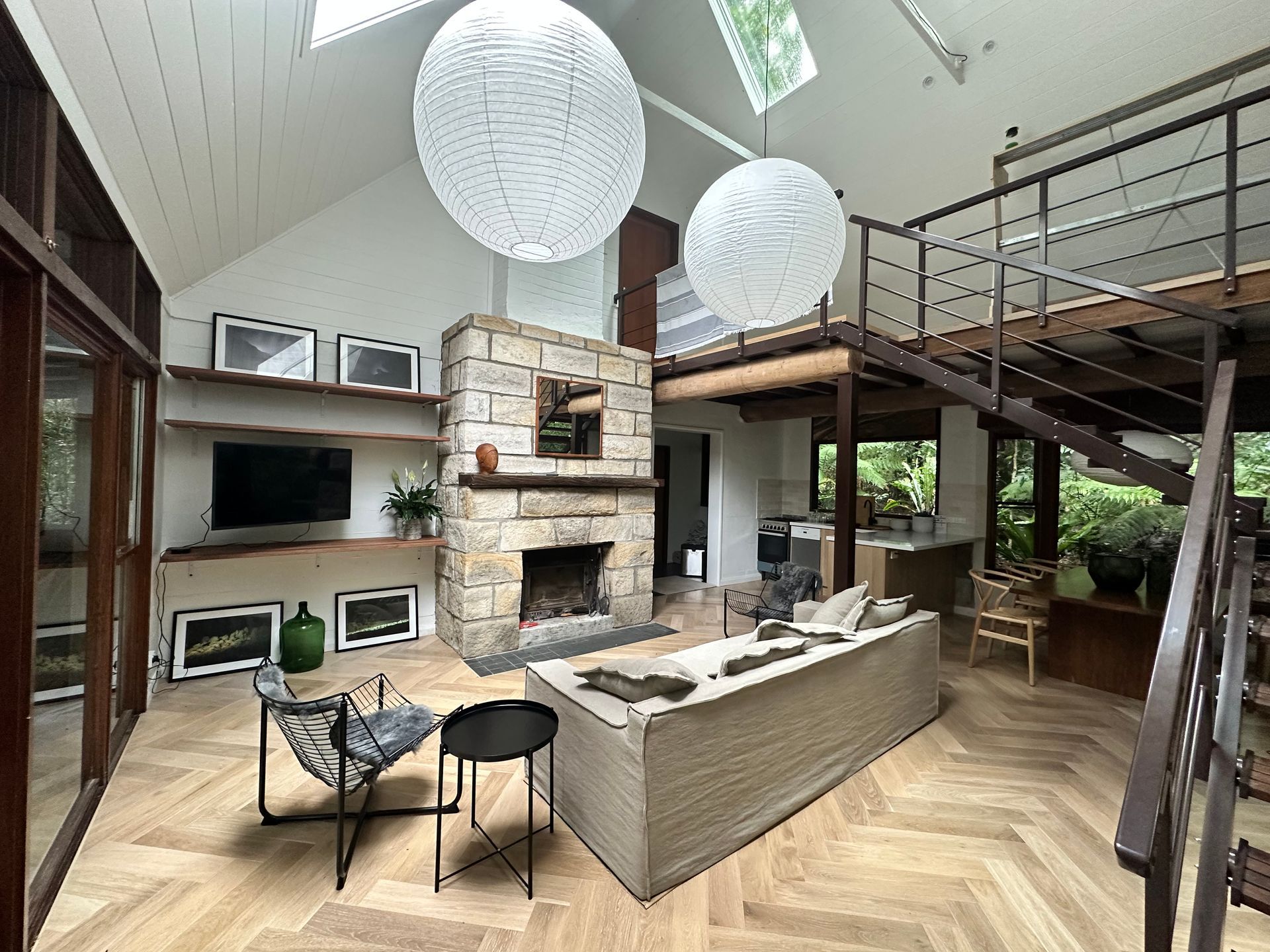 Spacious Living Room With Fireplace, Loft, and Large Windows, Light Wood Floor — DG Electrical & Fire In Kiama, NSW