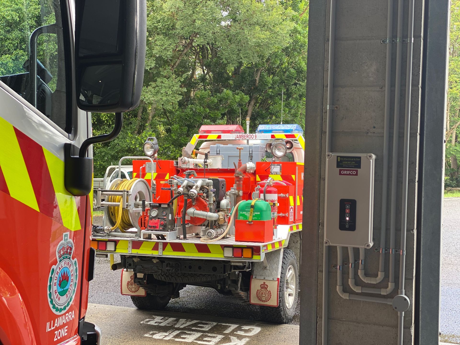Fire Truck in a Station Bay, Visible From the Side and Rear, With a Red and Yellow Colour — DG Electrical & Fire In Kiama, NSW