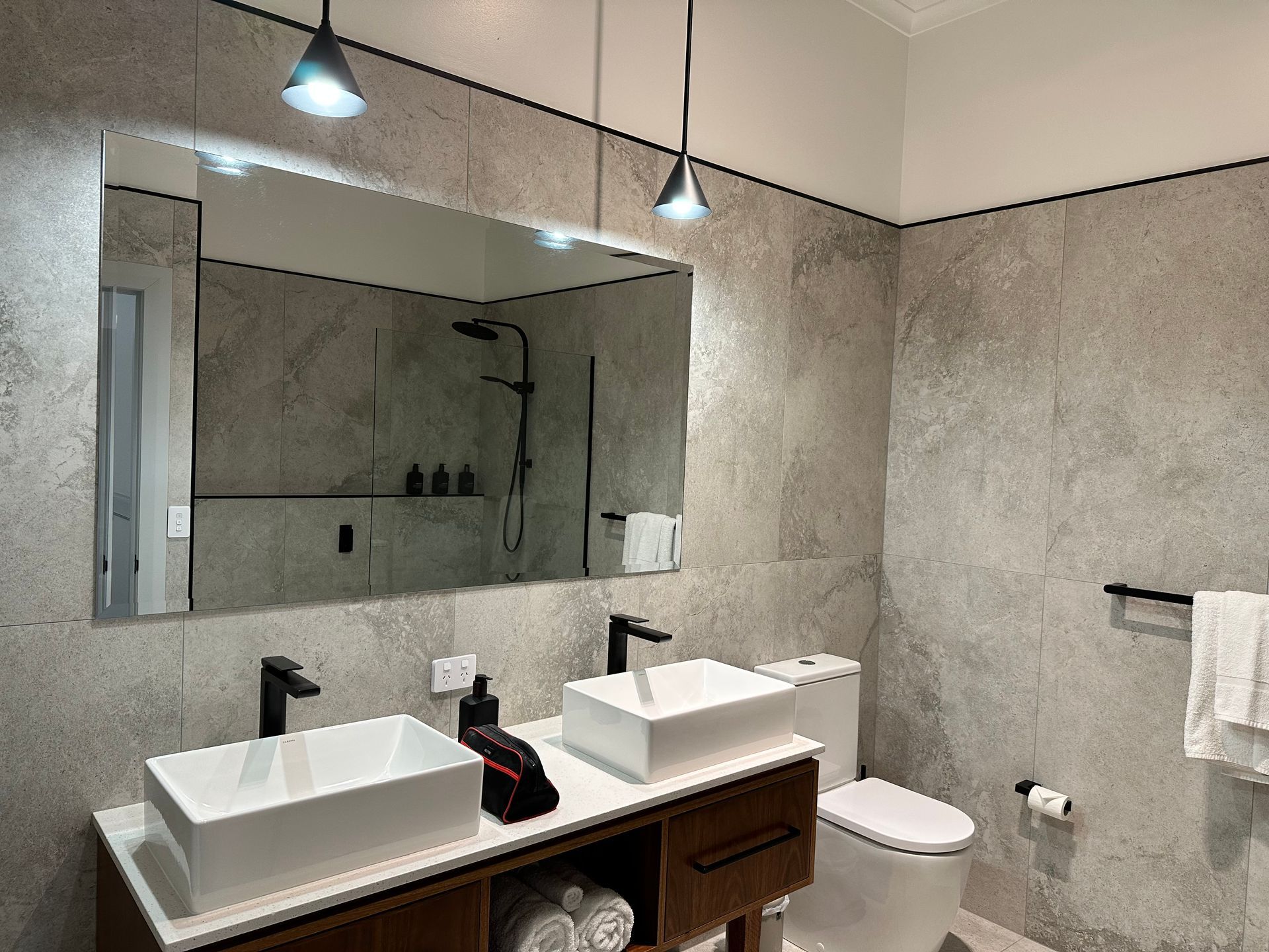Modern Bathroom With a Large Mirror, Double Sinks, and Grey Tile Walls — DG Electrical & Fire In Kiama, NSW