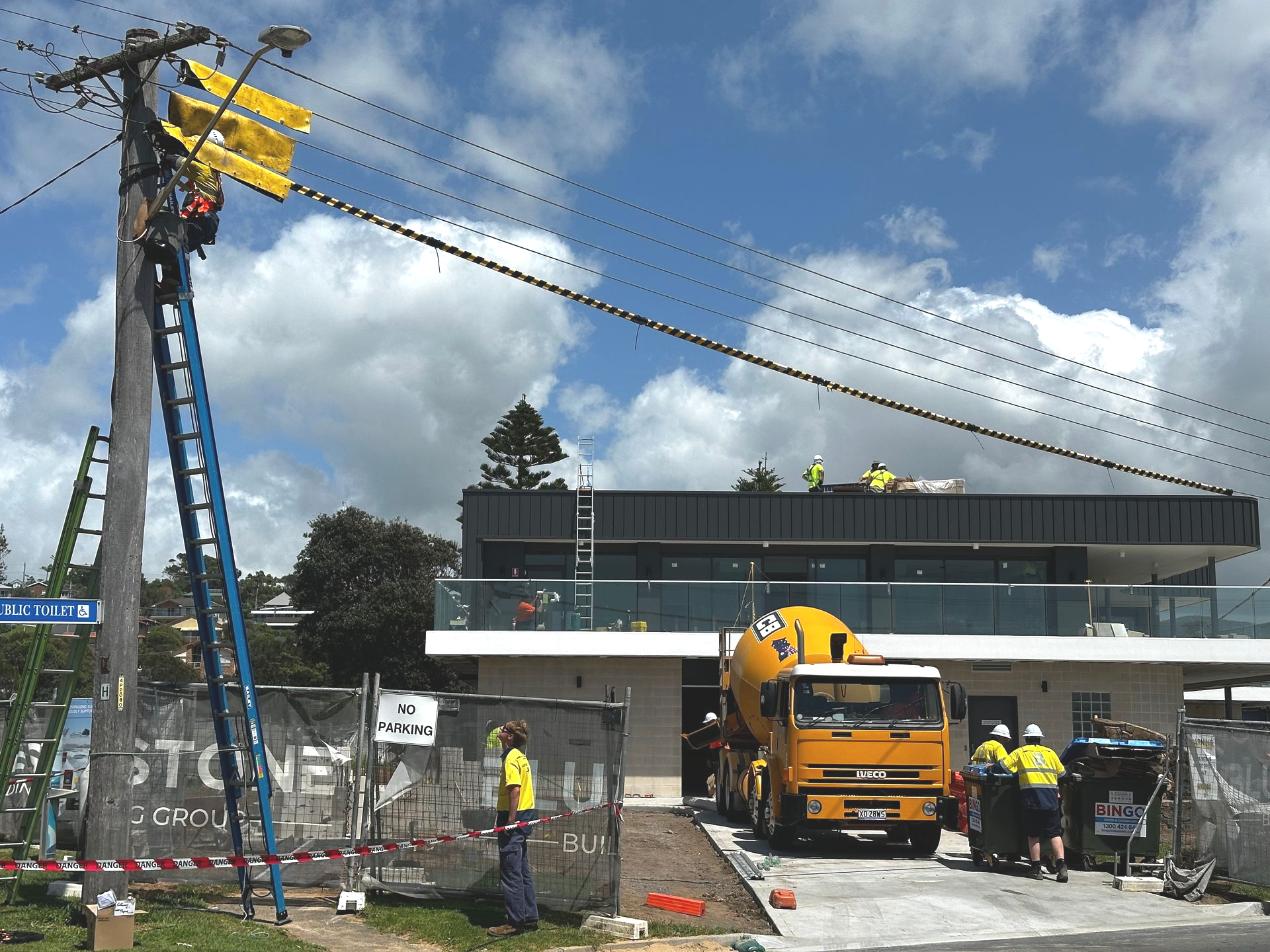 Construction Site With Workers, a Cement Truck, and a Utility Pole — DG Electrical & Fire In Gerringong, NSW
