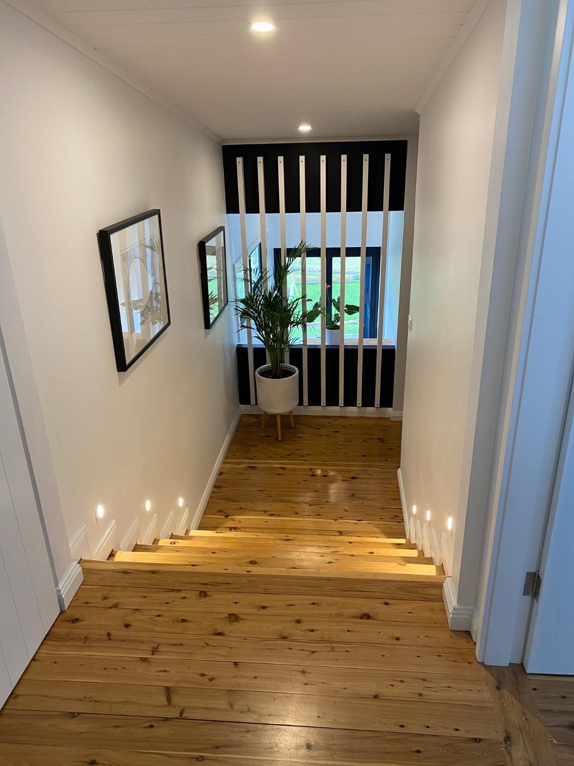 A Hallway With Wooden Floors And Stairs Leading Up — DG Electrical & Fire In Gerringong, NSW