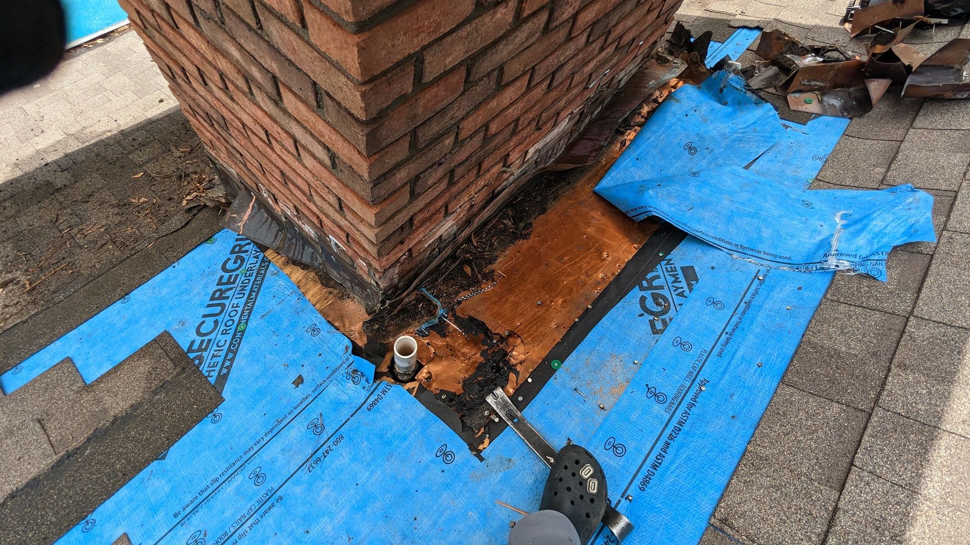 A brick chimney is sitting on top of a blue tarp.