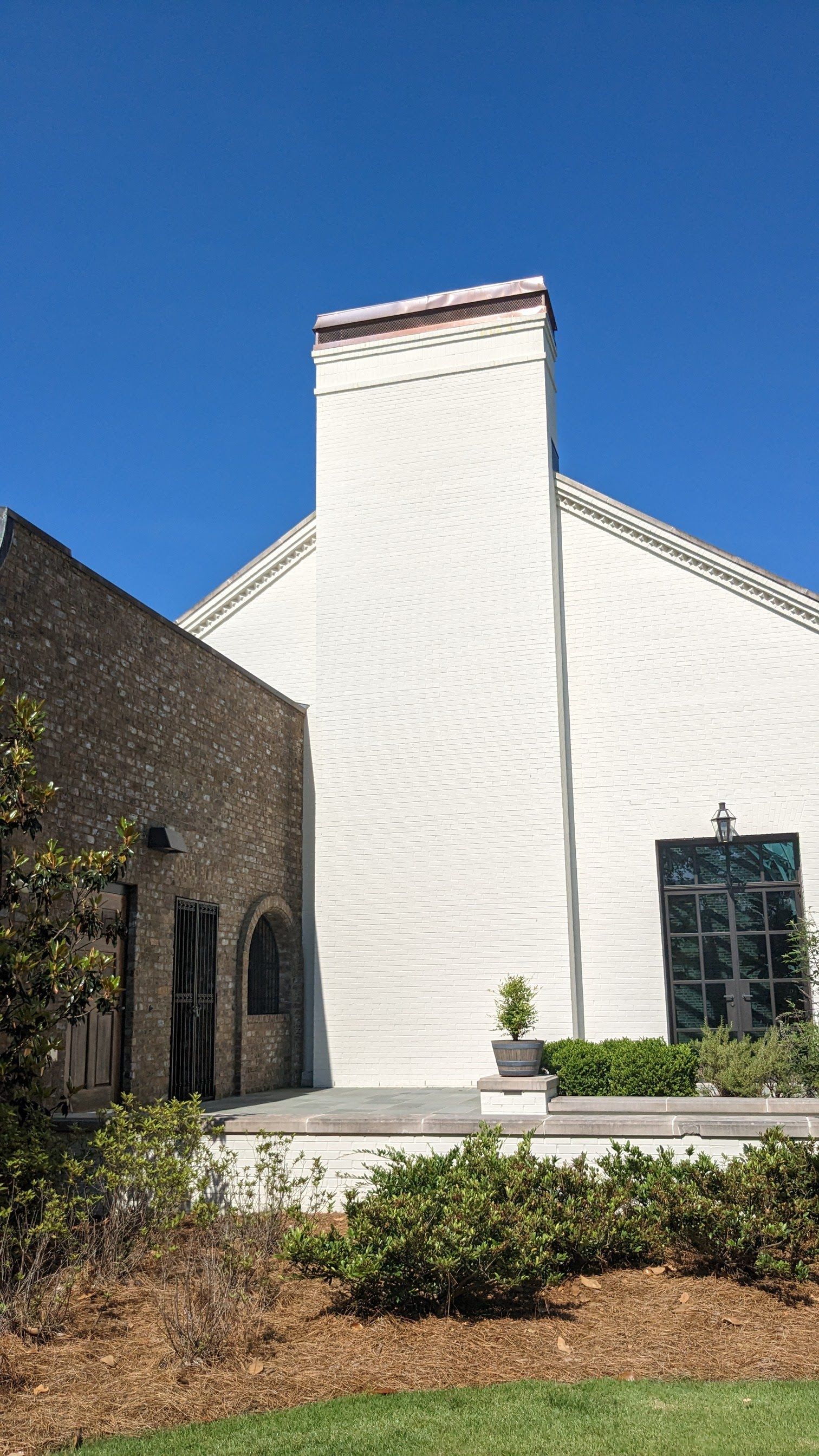 A large white building with a chimney on the side of it.