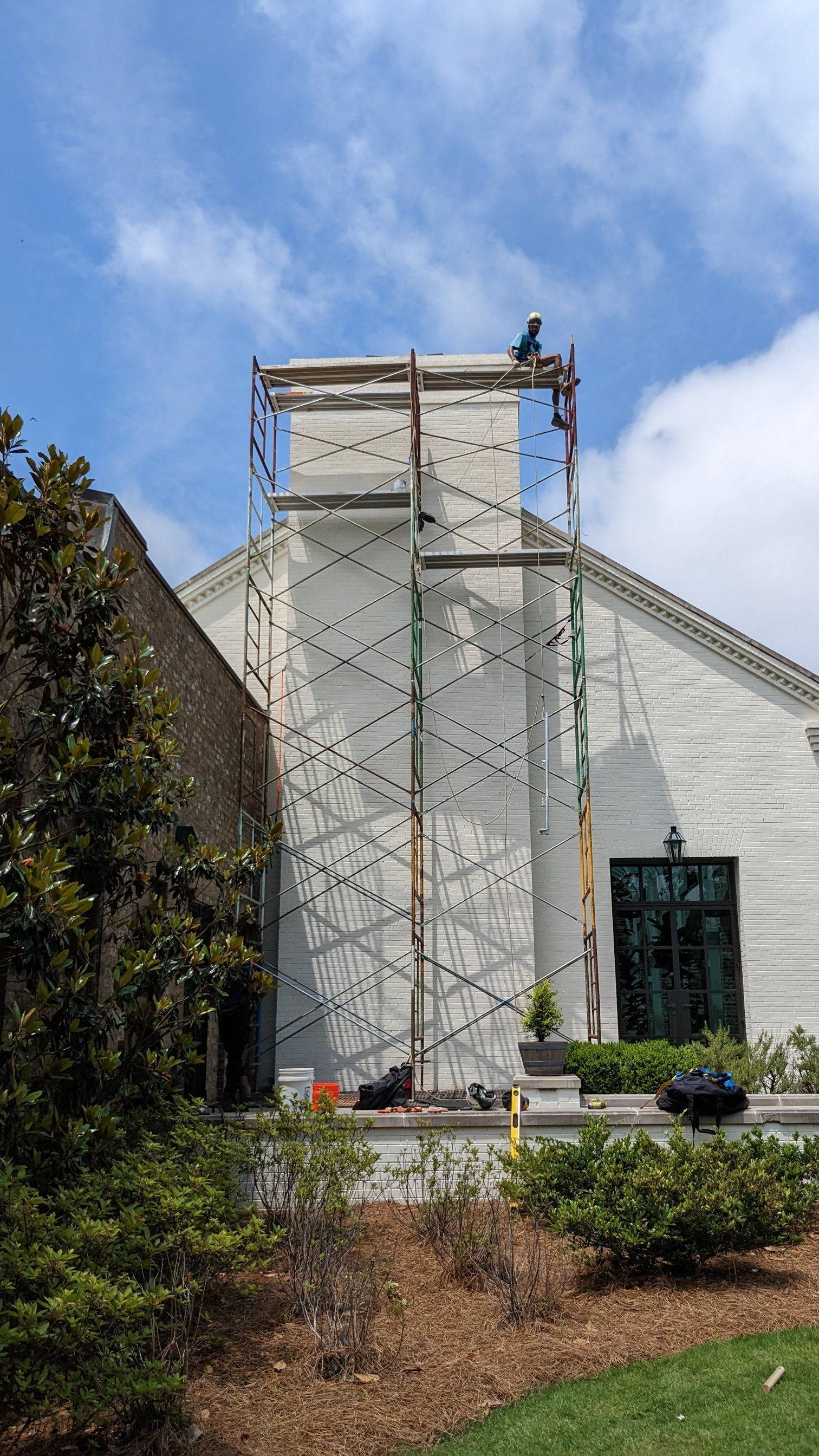A man is standing on a scaffolding on top of a building.