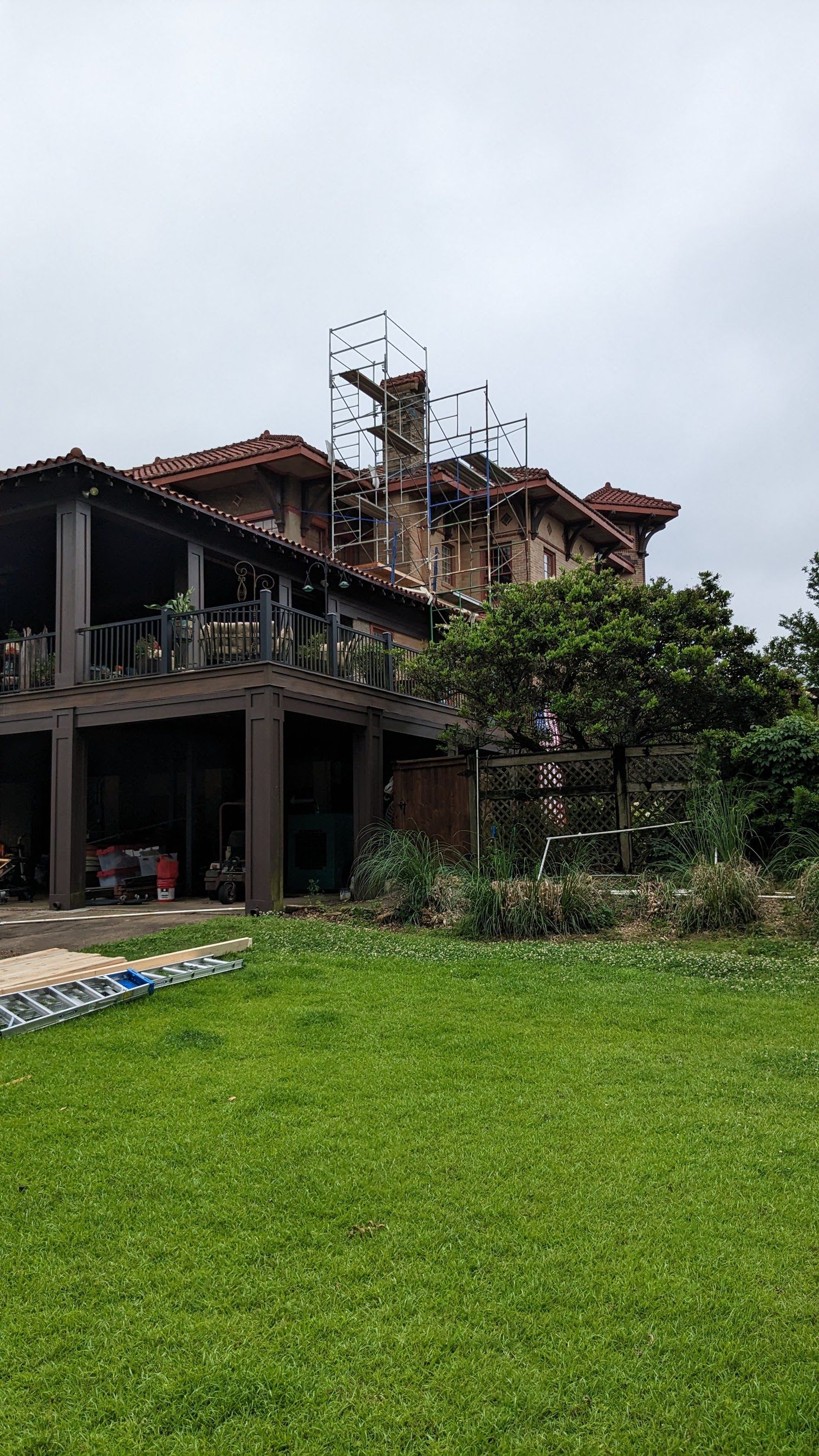 A large house is being built in the middle of a lush green field.