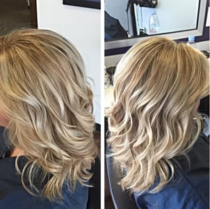 Woman with wavy blonde hair, styled to one side, in salon setting.