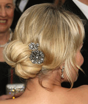 Blonde hair styled in a low bun, with a jeweled hair clip and drop earrings.