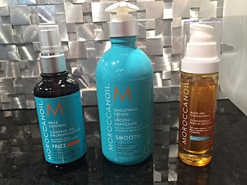 Three Moroccanoil hair products: Frizz Control, Smoothing Lotion, and Blow-Dry Perfector.