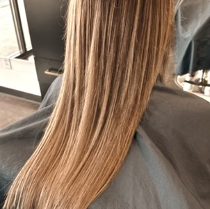 Long blonde hair, freshly styled and straightened in a salon.