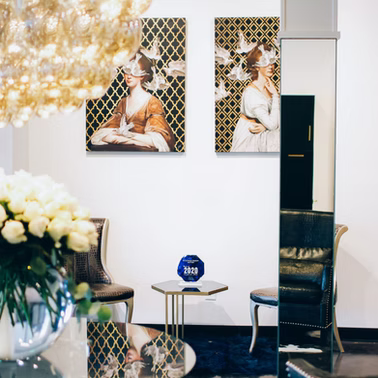 Elegant room with art, two chairs, and a small table with an award. Mirror reflects the room.