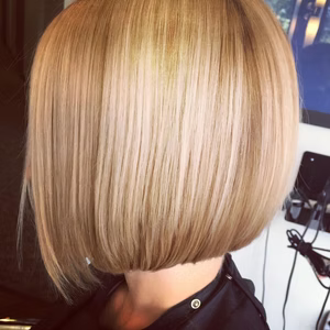 Blonde bob haircut, sleek and smooth, slightly angled, with visible layering.