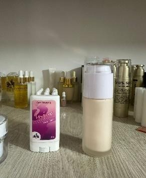 Dos productos para el cuidado de la piel en un estante: una barra blanca con etiqueta rosa