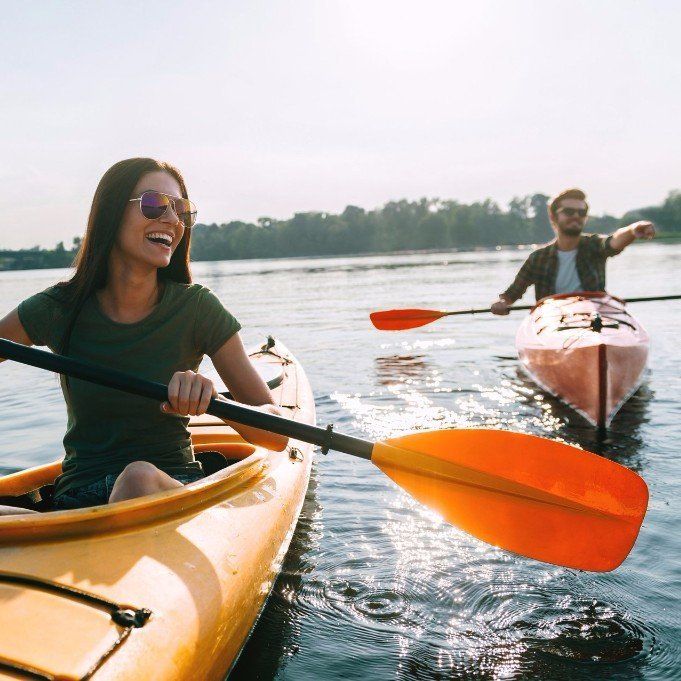A young couple smiling while kayaking
