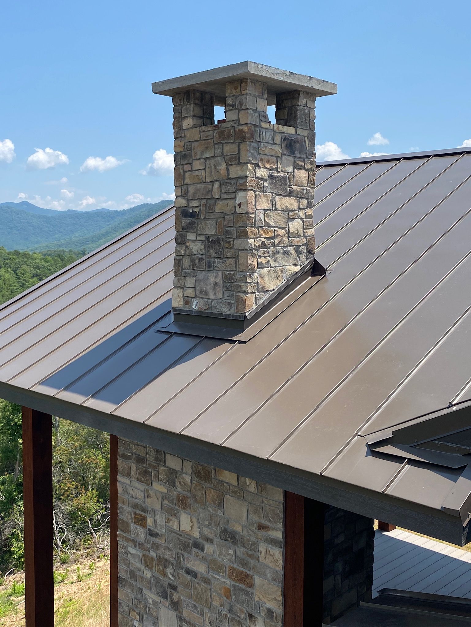 a stone chimney is on the roof of a house .