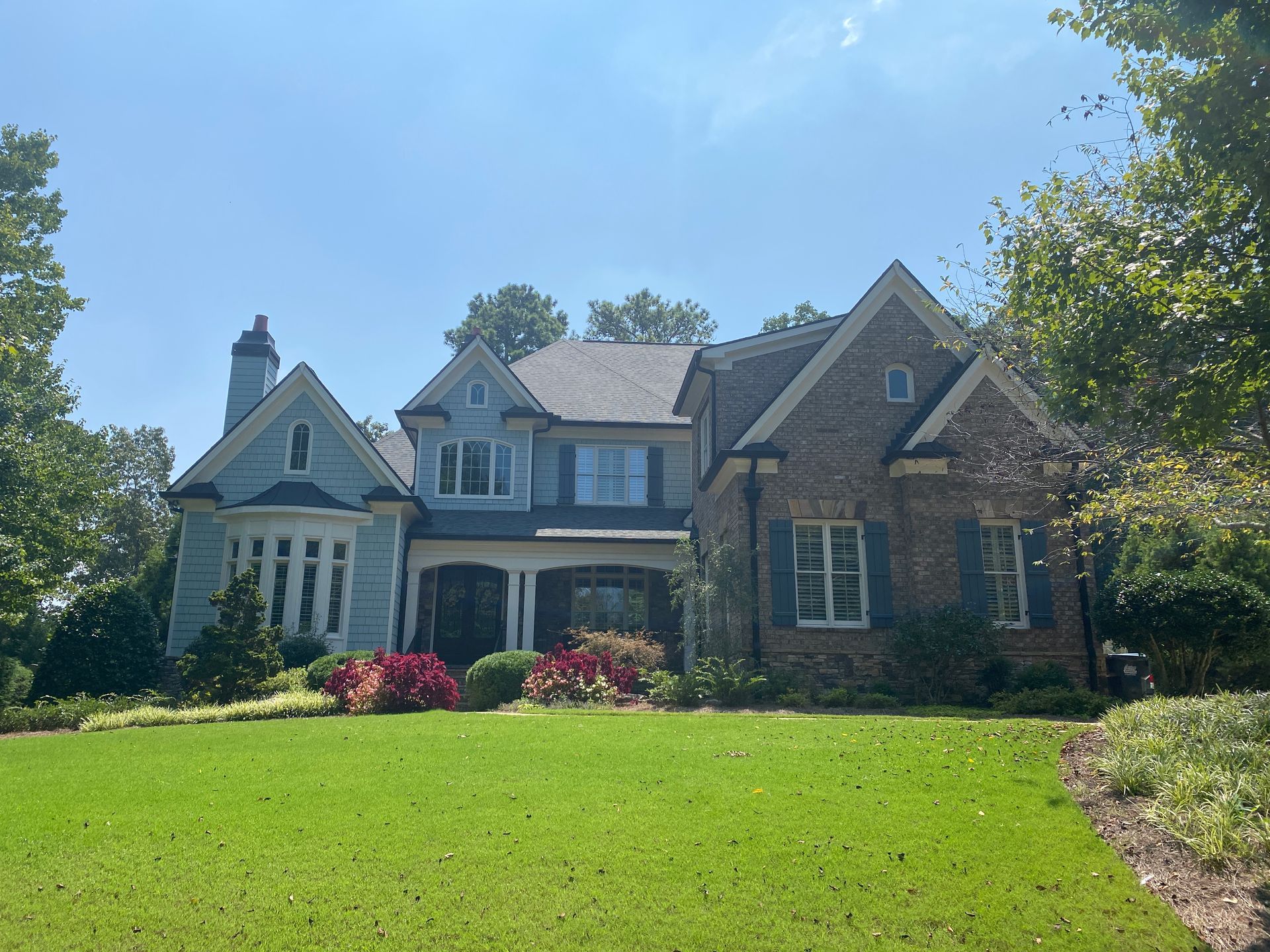 a large house with a lush green lawn in front of it