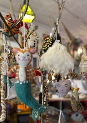 A bunch of stuffed animals are hanging from a tree.