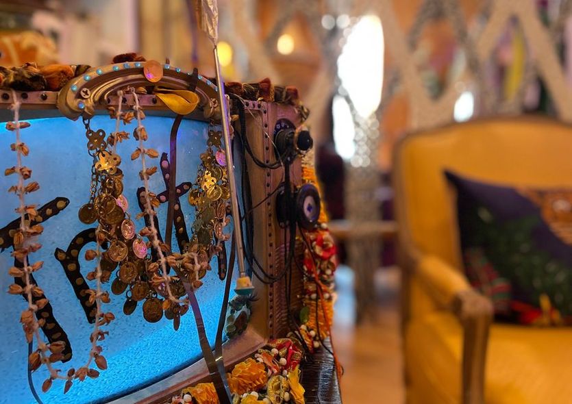 A chair with a yellow pillow and a necklace on it