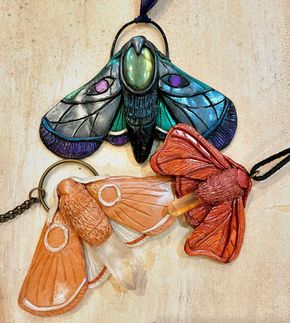 Three moth pendants are sitting on a table.