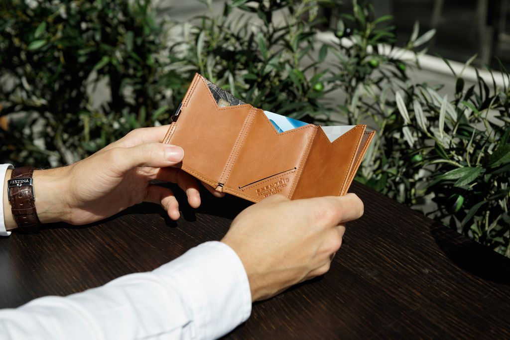 Homem com porta-cartões aberto com 3 espaços para armazenar cartões