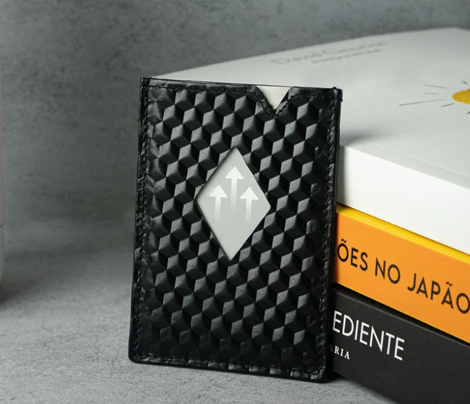 Porta cartões com padrão de cubos encostado a livros