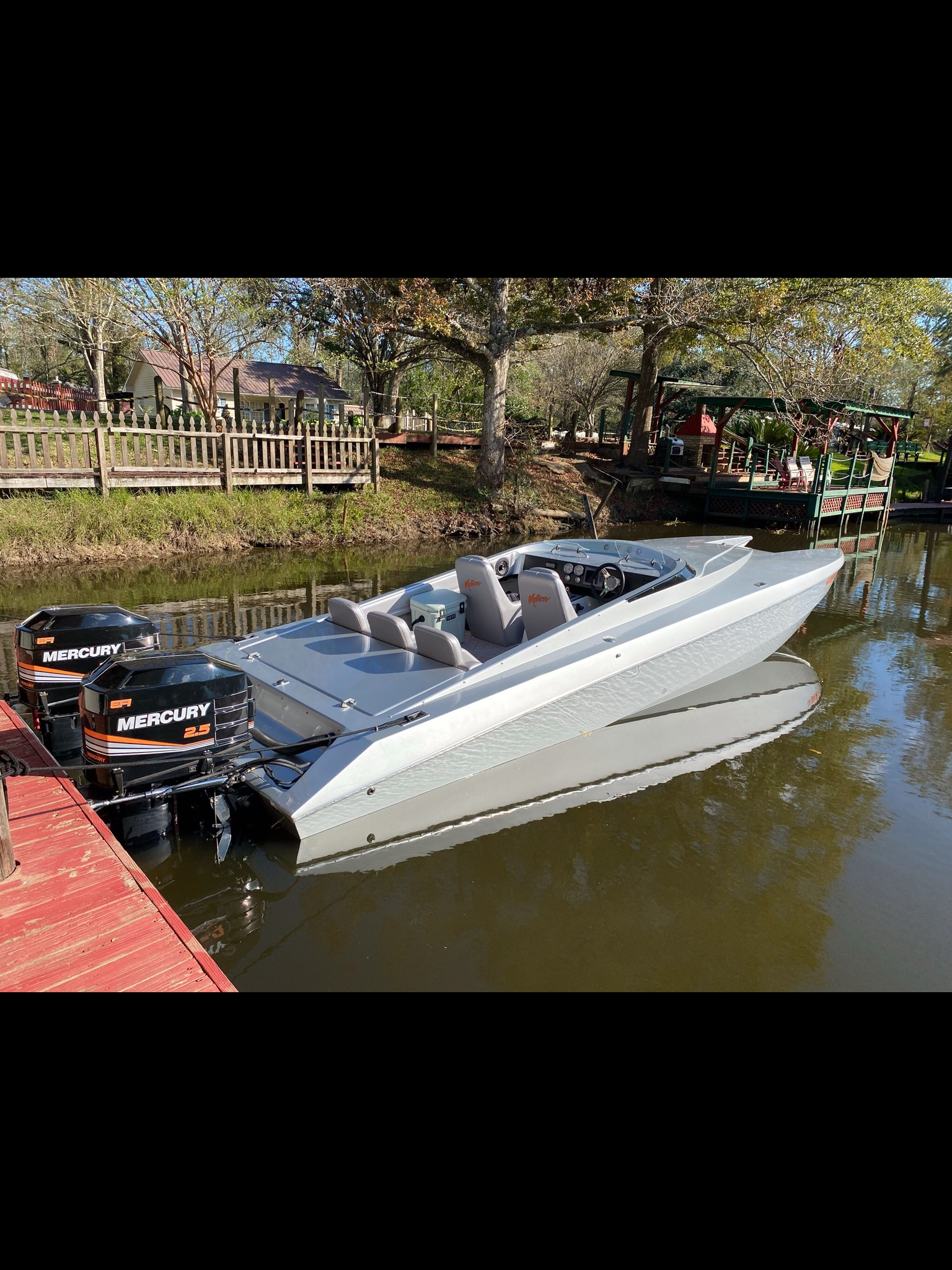 Warehouse interior with a boat on a trailer, a forklift, and building materials.