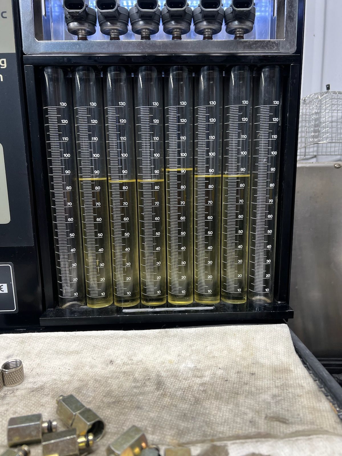 Shipyard worker inspecting a vessel's hull and propellers. Tools on a cart.