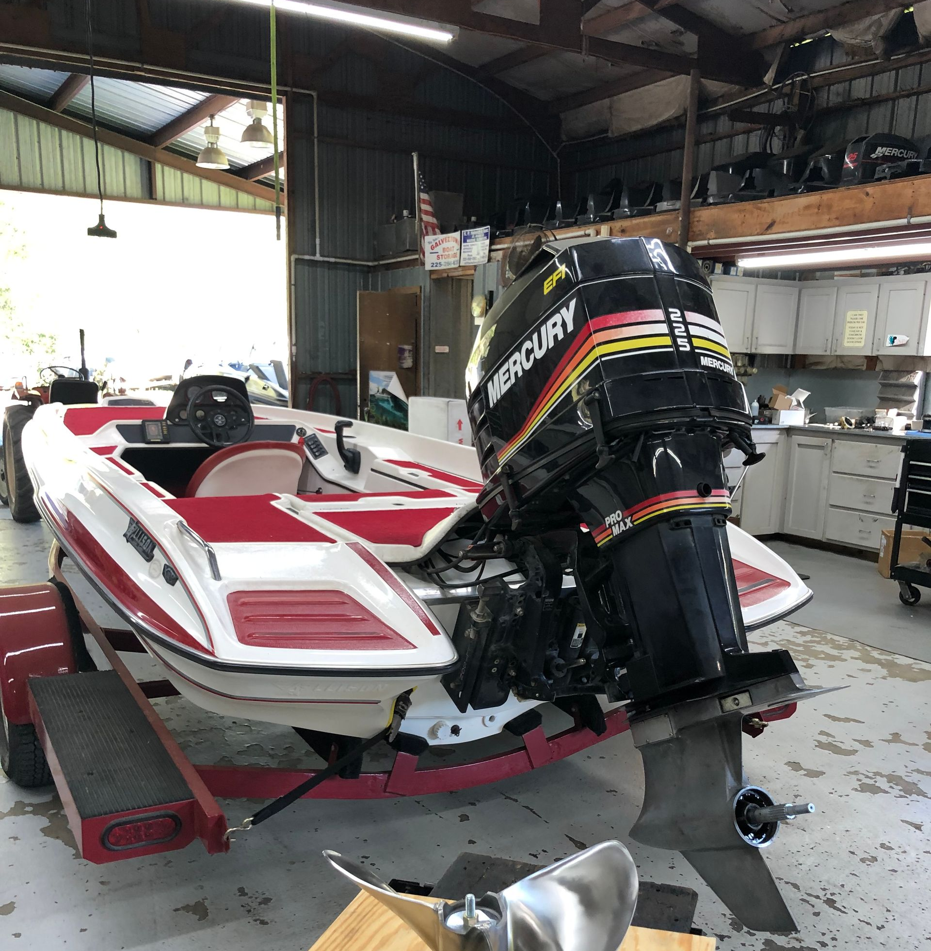 Boats are parked in front of a boat repair shop on a sunny day.