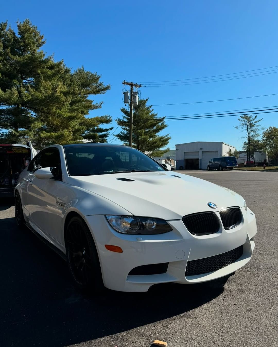 A white bmw  E92 M3 is parked in a parking lot.