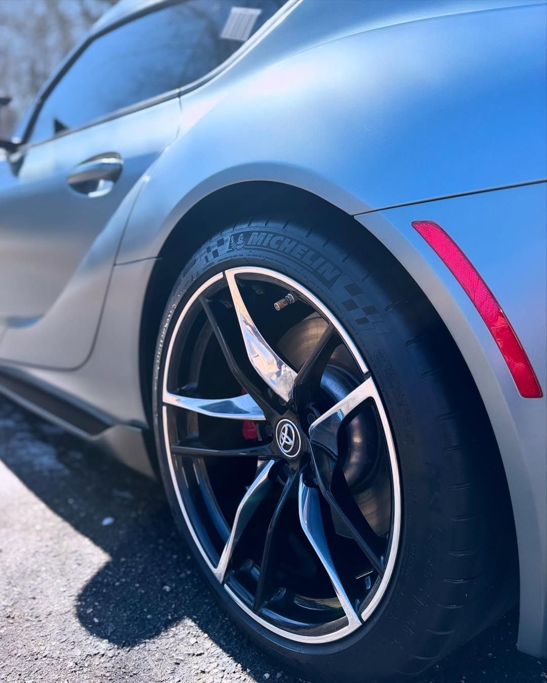 A silver car with a michelin tire on it