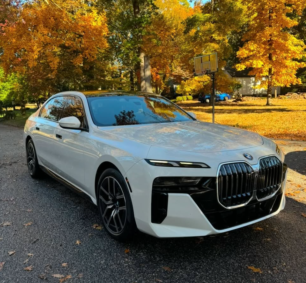 A white bmw is parked on the side of the road.