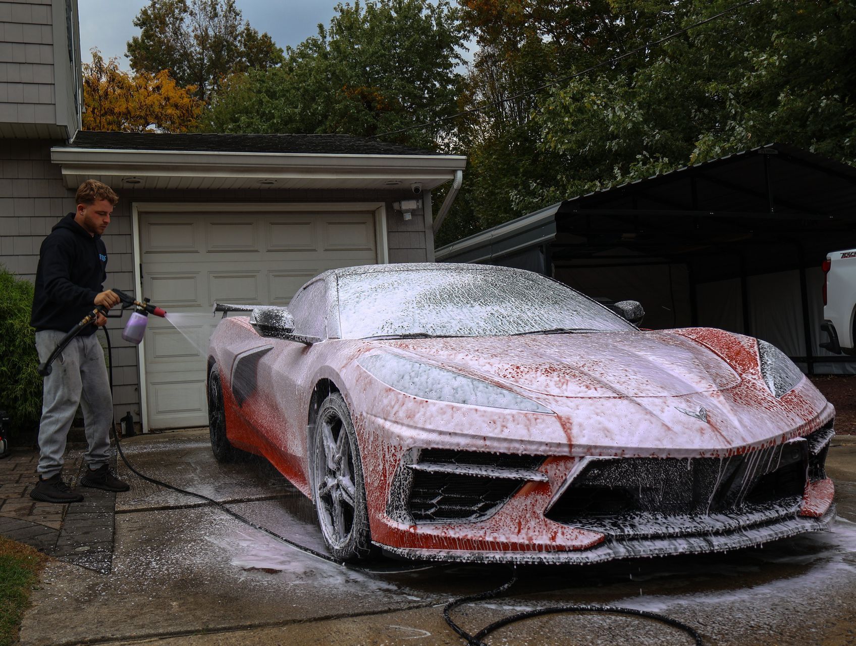 A blue bmw m3 is parked in front of a garage.