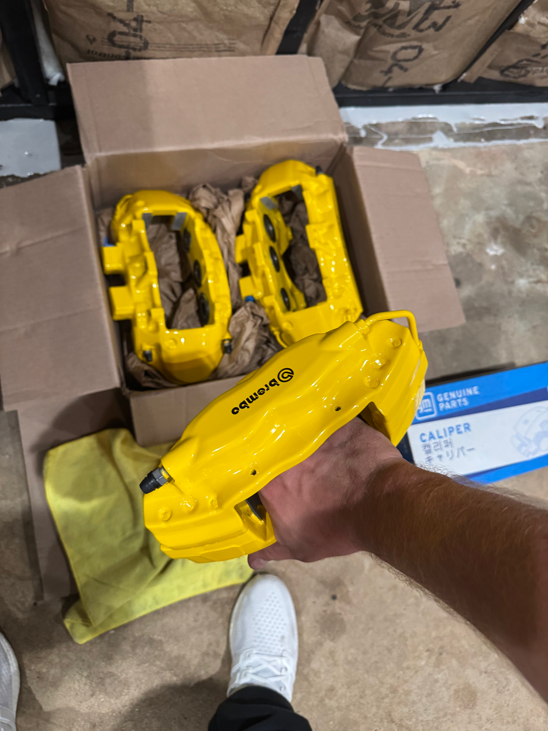 A person is holding a pair of yellow calipers in their hand