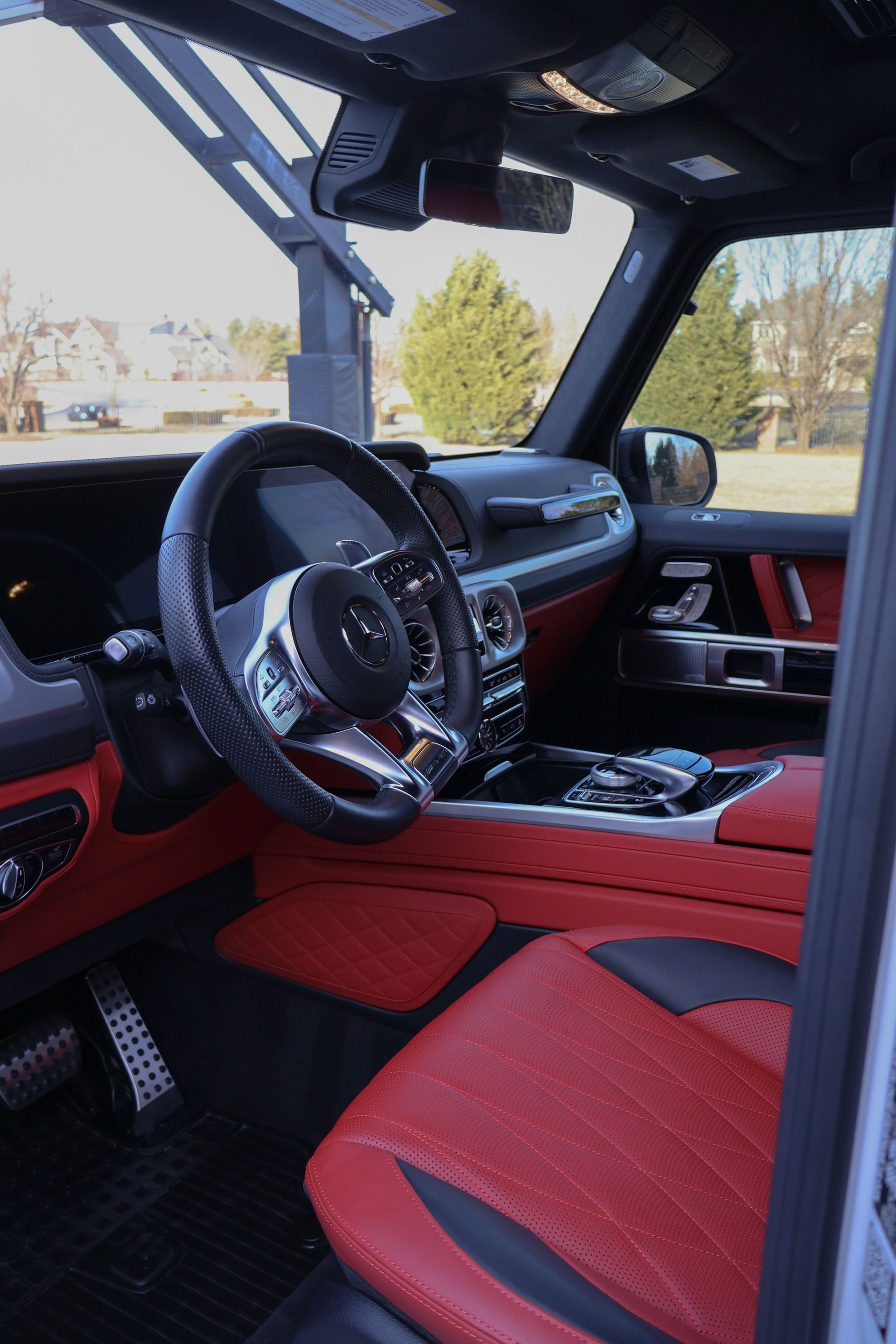 The interior of a car with red seats and a steering wheel.