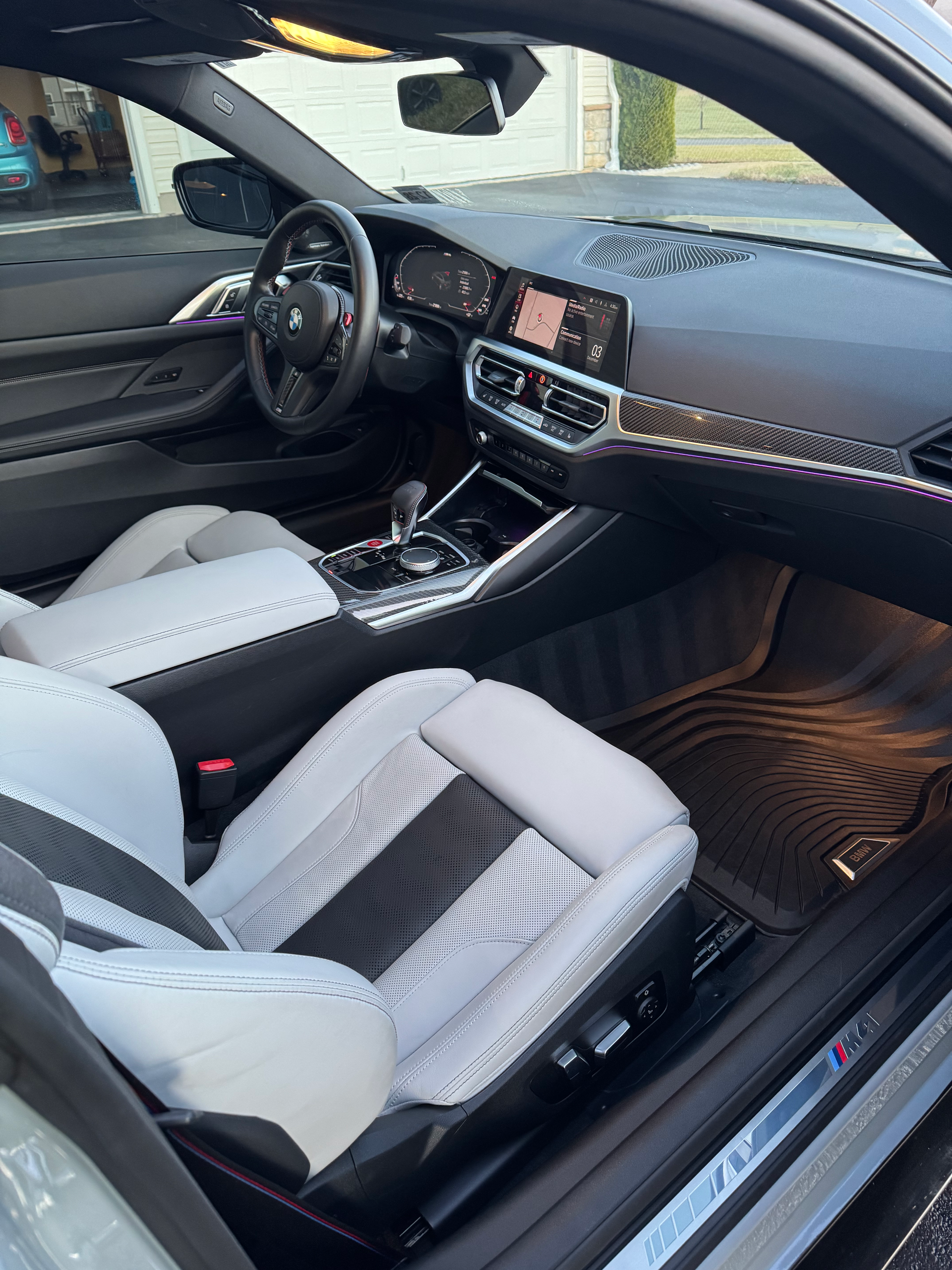 The interior of a bmw m4 is shown with the door open.