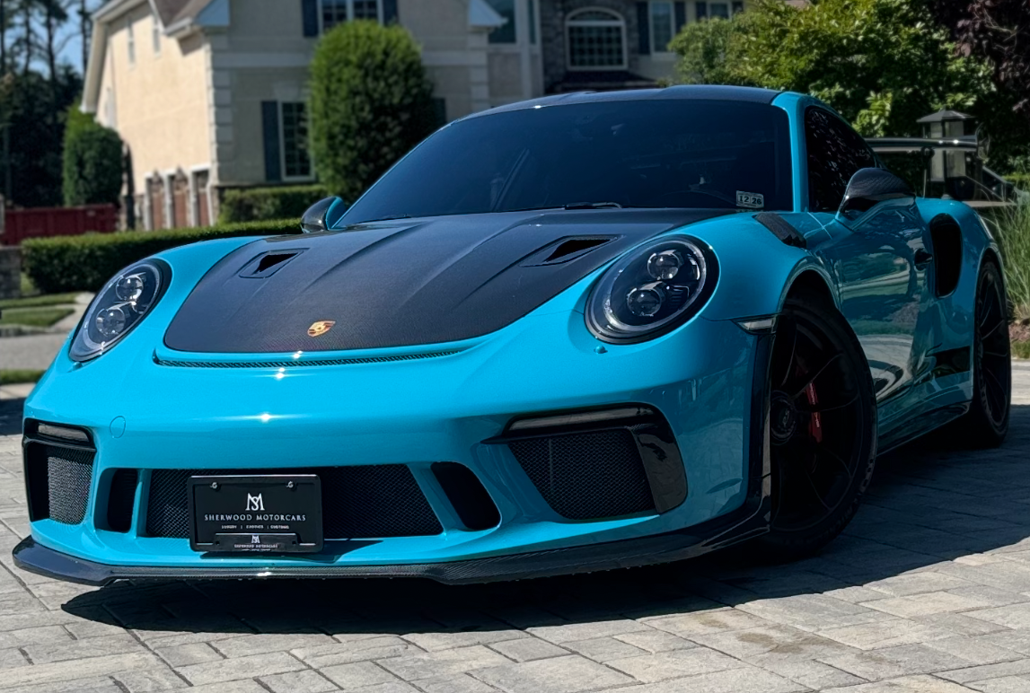 A white bmw x6 m is parked next to a black car.