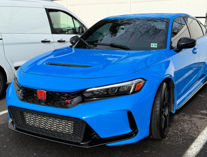 A close up of a blue car with black wheels and tires
