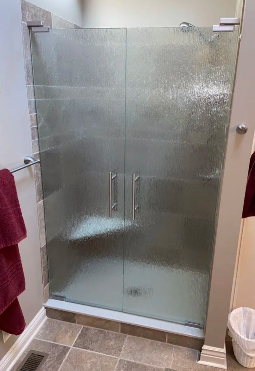 Bathroom shower with frosted glass doors and tiled floor