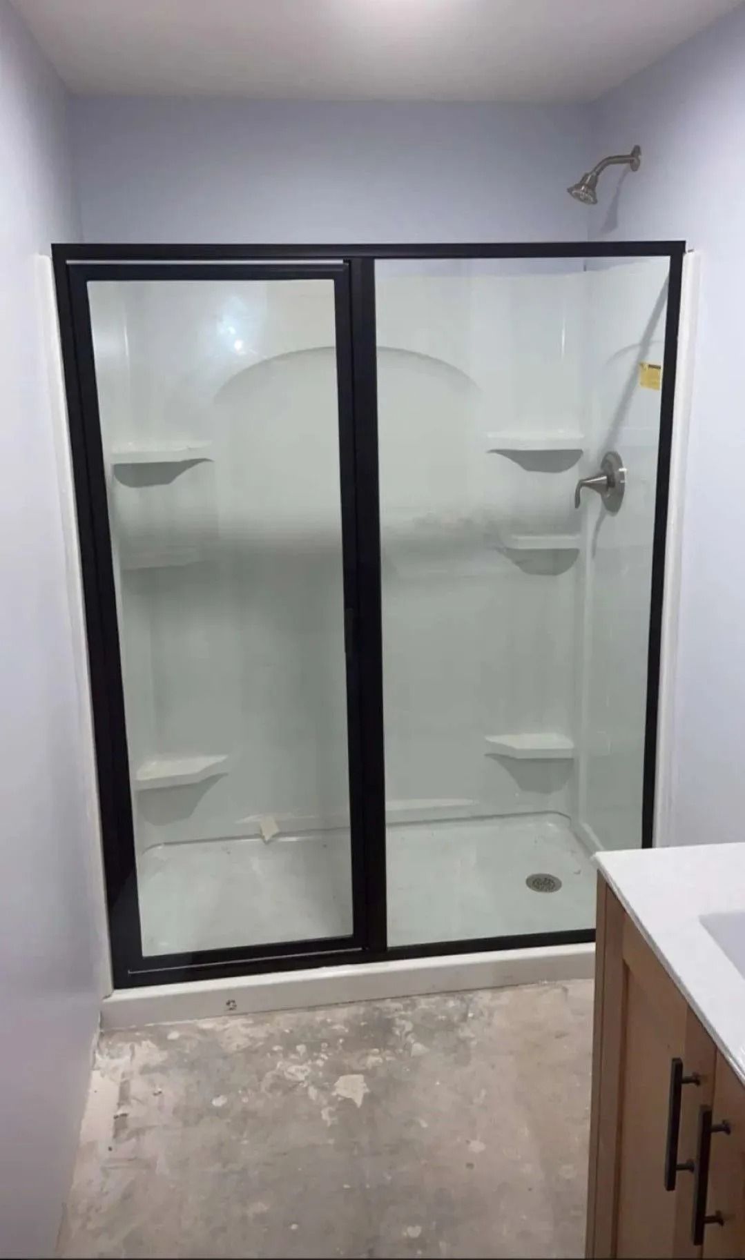 Small bathroom with a frosted glass shower enclosure and a vanity edge in the foreground.