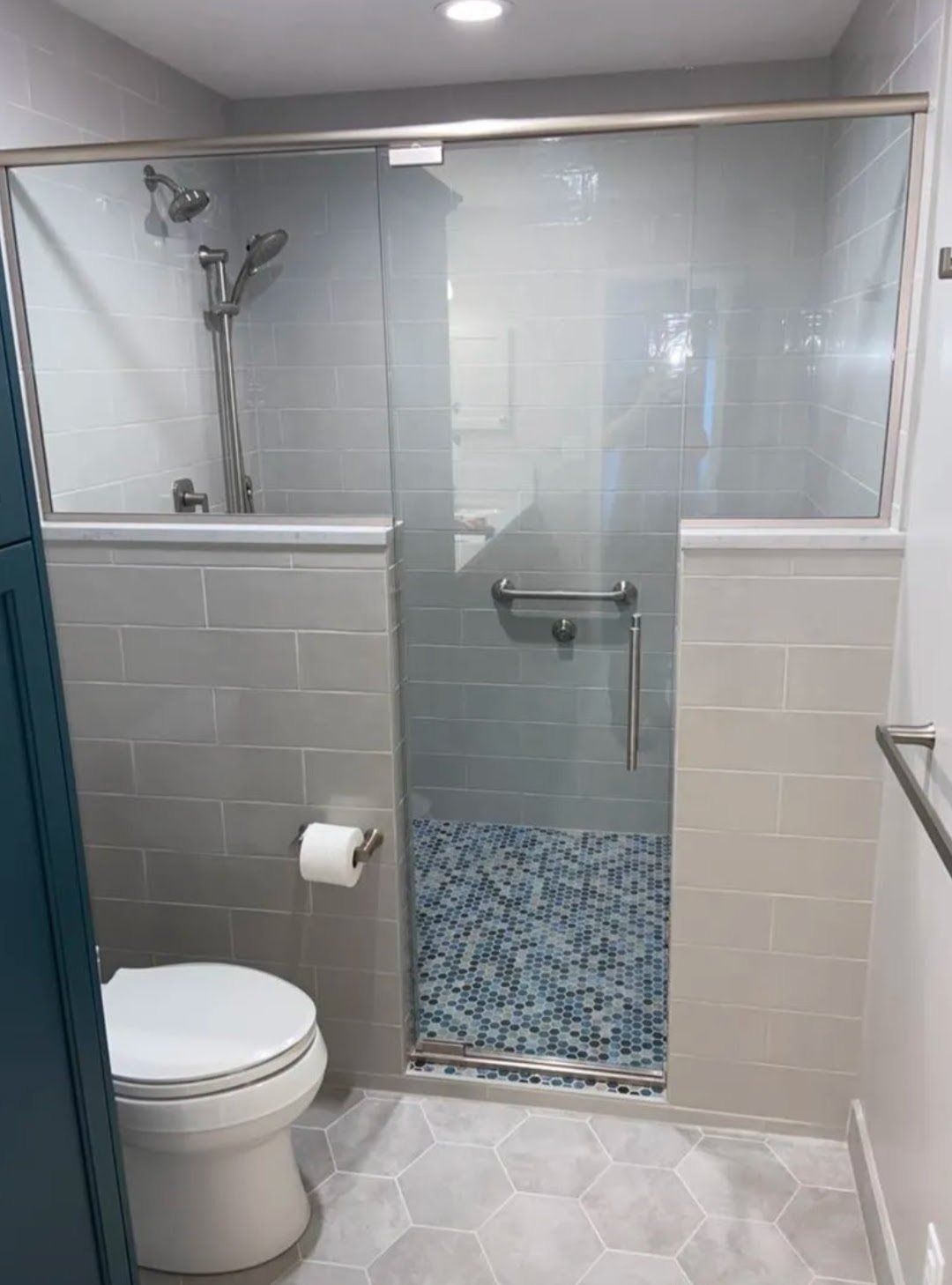 Accessible bathroom with toilet, walk-in shower, grab bar, and blue mosaic shower floor.