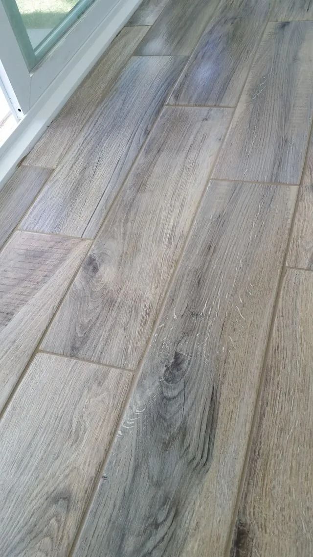 Light wood plank floor beside a glass wall or window