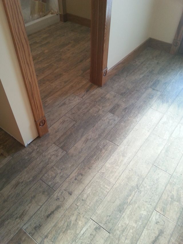 Wood-look flooring in a hallway with two open doorways and white walls