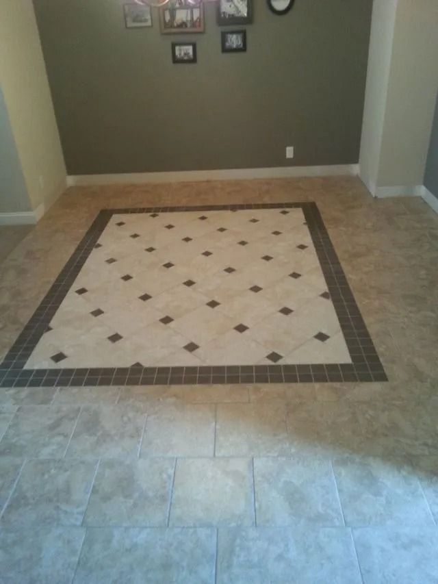 Empty tiled foyer with a decorative square inlay and beige walls